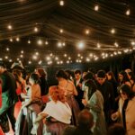 People Attending an Event Walking Under Light Strings