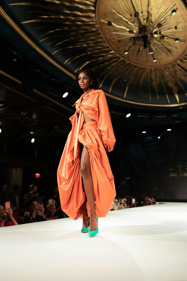 Woman in Orange Robe Standing on White Floor